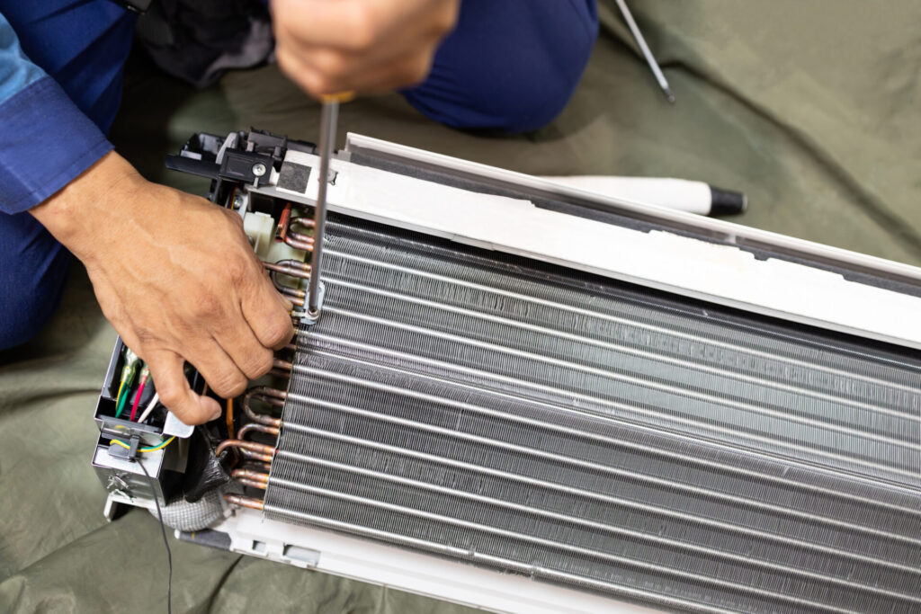 Technician is fixing or checking the evaporator system, troubleshooting air conditioning unit or dismantling for air conditioner fan coil unit cleaning,repair and maintenance,install air conditioner